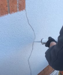 Repairing wall cracks and holes with filler before paint spraying